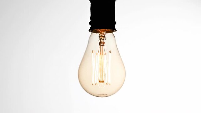 Extreme slow motion shot of a single bare light bulb fixture swinging gently like a pendulum against an overwhelmingly bright blank white background physics, isolated, empty space
