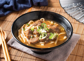 Delicious bowl of hearty beef noodle soup ready to enjoy, perfect for food blogs and Asian cuisine promotions with a touch of culinary delight