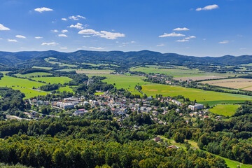 Fototapeta premium Aerial drone view of Zulova town in the Czech Republic historic church on Bozi Hora hill, traditional rooftops, surrounding greenery, and the peaceful town layout captured in clear daylight