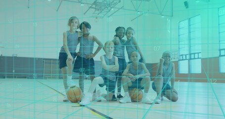 Posing seven kids wearing matching sleeveless jerseys and shorts in school gym, two basketballs