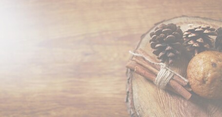 Showing rustic wood slice on right table with cones, twine-tied cinnamon stick, cookie, copy space