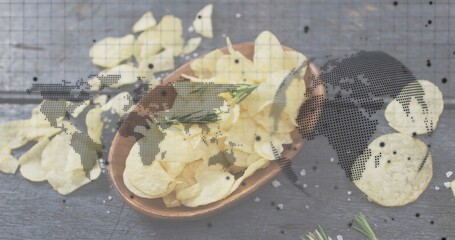 Displaying wood bowl rippled potato chips spilling across dark table, rosemary, salt, map overlay © vectorfusionart