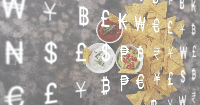 Displaying triangular tortilla chips and three bowls on dark tabletop, currency overlay, copy space