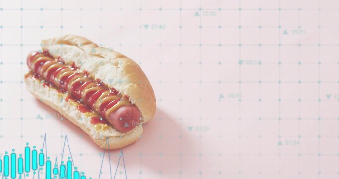 Displaying single hot dog resting on pastel pink grid tabletop showing mustard ketchup, teal charts
