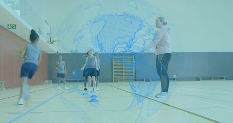 Leading coach guiding children in gray tops navy shorts running to cones in gym, with basketball