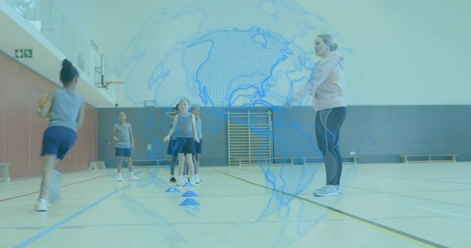 Leading coach guiding children in gray tops navy shorts running to cones in gym, with basketball