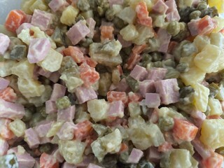 Russian olivier salad - boiled vegetables with green peas and sausage with mayonnaise. Traditional New Year's salad