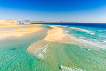 Fototapeta premium Playa de Sotavento is a famous beach on the southeastern coast of Fuerteventura, known for its long stretches of golden sand, turquoise water, and consistent winds