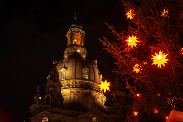Christmas in Dresden, Saxony, Germany. View of the Frauenkirche and a Christmas tree decorated with Christmas stars.