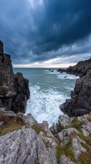 Dramatic coastal landscape with rugged cliffs and turbulent waves under a moody sky at sunset