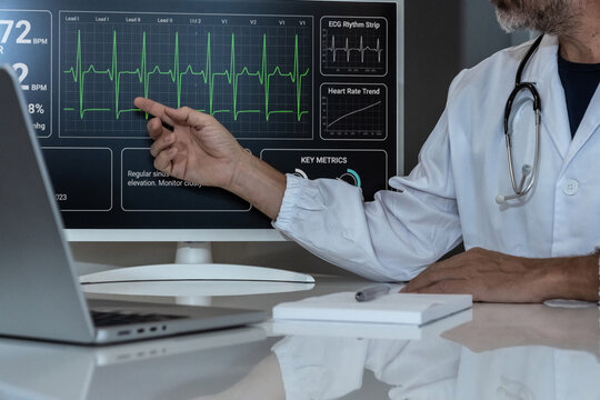 Cardiologist monitoring patient's heart rate and ECG analysis on a digital display.