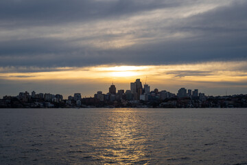 Naklejka premium Sydney skyline at sunset with golden reflections on the water