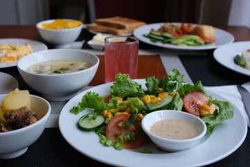 A beautifully presented meal features tender broccoli, savory dumplings, and fresh salad, perfectly arranged on a stylish table in a warm ambiance during dusk. High quality photo
