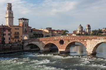 Obraz premium Verona’s Ponte Pietra arches over the Adige, blending Roman engineering with river motion and city charm.
