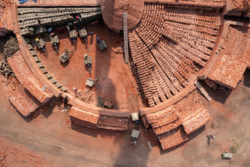 Aerial view of a brick kiln with its distinctive circular design, showcasing the earthy tones and structured layout of the brick-making process, Bogura, Rajshahi Division, Bangladesh.