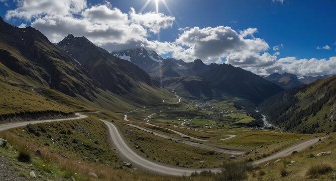 winding mountain road through alpine valley with village and dramatic peaks under cloudy blue sky - Powered by Adobe