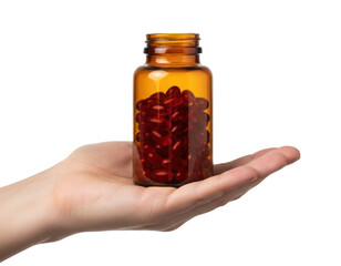 Hand holding an amber glass bottle filled with red softgel capsules against a deep, solid hue