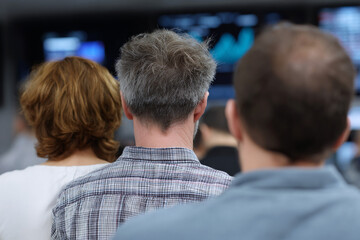 Investors watching stock market data on large screens.