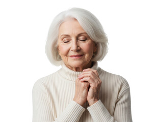 Serene senior woman with white hair and closed eyes, hands clasped in contemplation while wearing a cream turtleneck