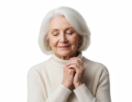 Serene senior woman with white hair and closed eyes, hands clasped in contemplation while wearing a cream turtleneck