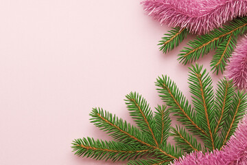 Pink Christmas background with fir branches and tinsel, copy space