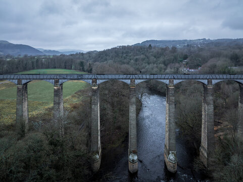 Aerial view of the Pontcysyllte Aqueduct standing tall over the River Dee, a testament to engineering amidst the rolling hills, Llangollen, Wales, United Kingdom.