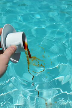 a person holding a cup of coffee in front of a pool