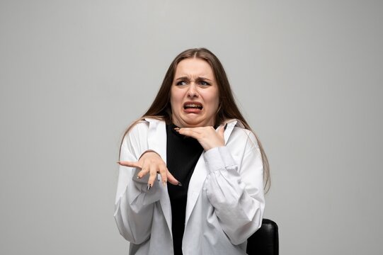 Woman reacting with disgust and fear, making dramatic expressive face in studio portrait