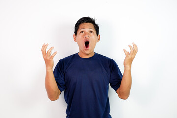 Surprised Young Man Shouting Expressively While Looking Up in Navy Blue T-Shirt Against White Studio Background.