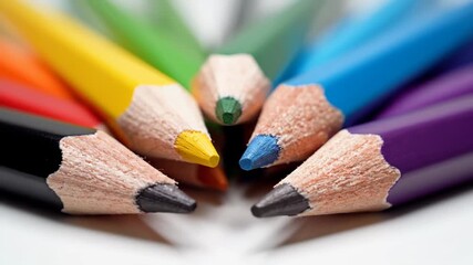 Colorful Pencils Arranged on White - This close-up video features a collection of sharpened colored pencils arranged neatly in a circular pattern on a bright, clean white surface. - Powered by Adobe