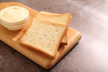 Bread slices with butter on grey table, closeup. Space for text