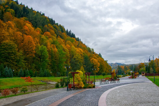 Embankment on Grajcarek river with wooden benches and lanterns in Szczawnica at autumn cloudy day, Pieniny, Poland. Szczawnica is one of the oldest and most beautiful spa resorts in Poland