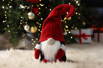 Obraz premium Funny Christmas gnome on flurry rug in decorated room