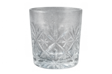 Empty crystal glass tumbler with a decorative faceted pattern on transparent background, ready for beverages or cocktails