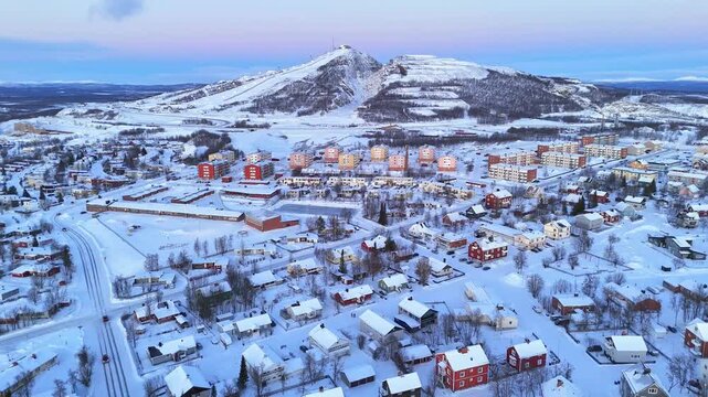 Kiruna, Lapland, Sweden, beautiful aerial view of the colorful houses and of the hill with ski slopes, during the arctic winter and polar night