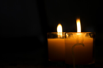 A candle burned on a glass holder in the dark, a symbol of hope.	