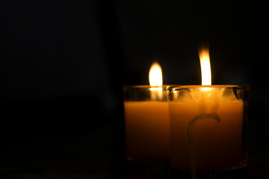 A candle burned on a glass holder in the dark, a symbol of hope.	 - Powered by Adobe