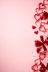Pastel pink flat lay with gifts, hearts, and ribbons. Valentine's Day vertical banner design.