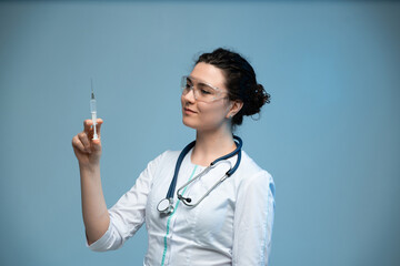 Nurse with protective eyewear examining syringe before injection in clinical medical environment