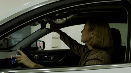 Client sitting comfortably in the new car, inspecting the interior and dashboard