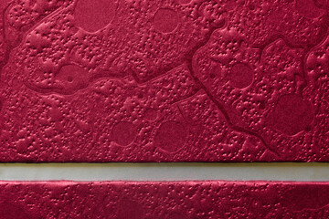 Red embossed texture background with a white horizontal strip for text. Close-up of a metallic gift box surface perfect for holiday greeting cards. Photo