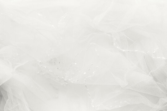 Delicate cloud white dancer tulle background. Blurred wedding veil with beads. Demonstrating color, trend 2026 year.