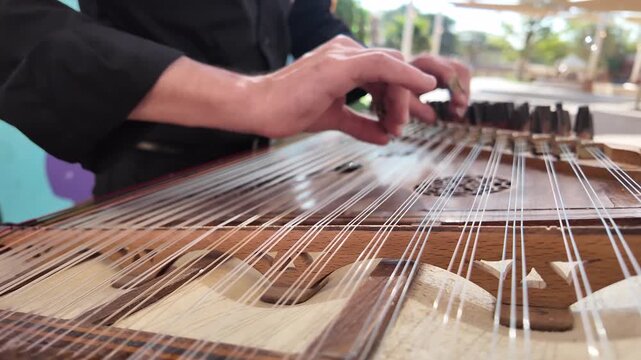 Omani guy playing on the qanun instrument  Middle Eastern music at celebration of The United Arab Emirates Independence Day ( 54th uae national day ) in Al Ain Zoo
