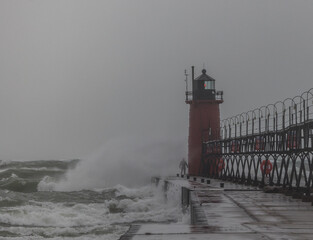 lighthouse with man getting hit with a wave