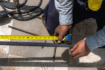 Construction worker working with measurement tape in construction site