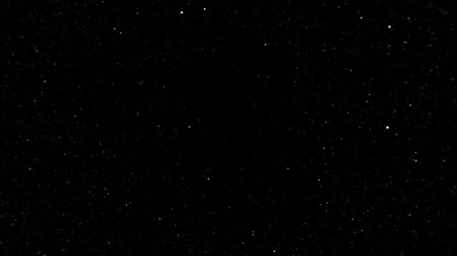 Dust particles moving on a black background in random directions. Abstract backdrop or for the use as overlay to create texture and depth. Infinite loopable footage in high quality.