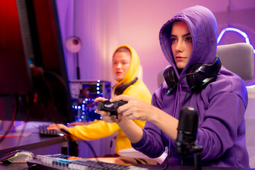 Two young gamers enjoy a fun and interactive streaming session in a vibrant gaming setup, showing teamwork, modern communication, and digital entertainment in an esports environment.