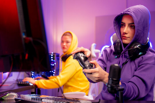 Two young gamers enjoy a fun and interactive streaming session in a vibrant gaming setup, showing teamwork, modern communication, and digital entertainment in an esports environment. - Powered by Adobe