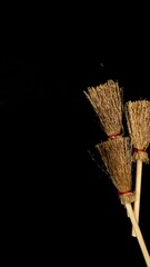 Mini witch brooms on black background, occult props, mystical composition, esoteric tools for magic and rituals