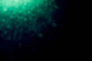 green mist and glitter against a dark background